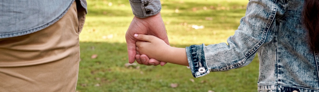 Parent and child holding hands.