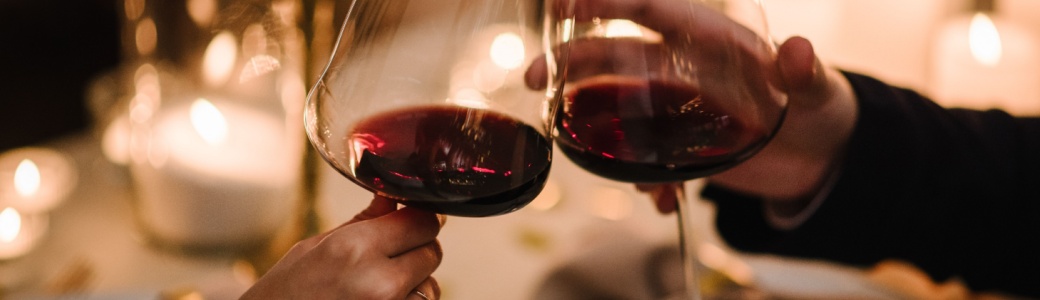 A couple toasting with a glass of wine.