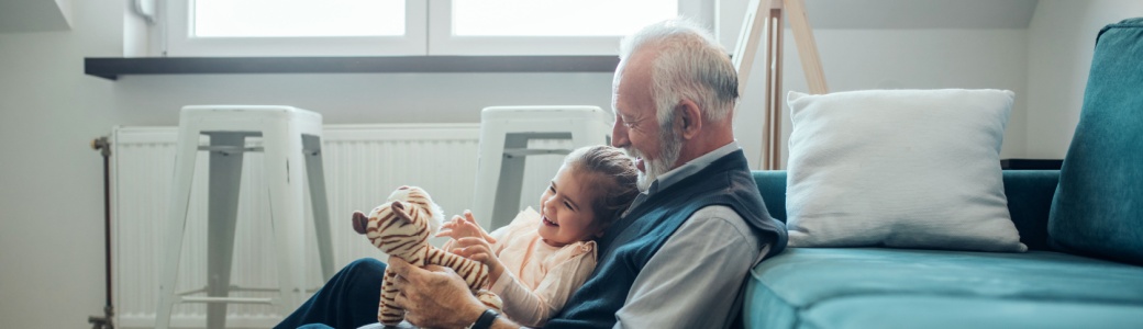 A grandfather playing with his granddaughter.