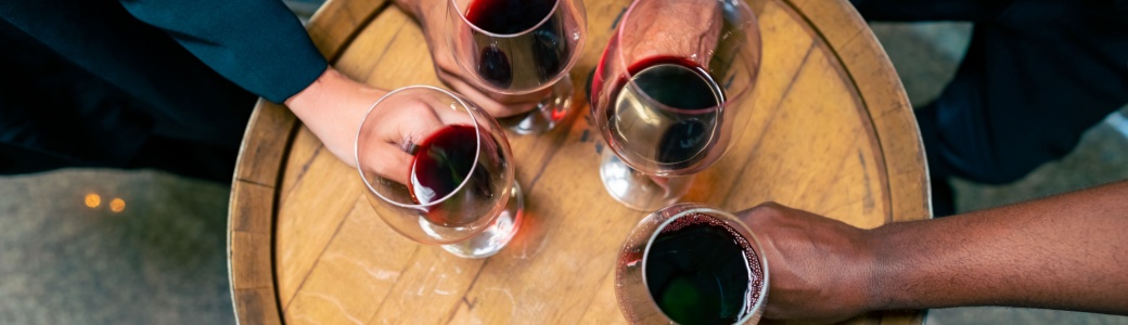 A group of people holding glasses of red wine.