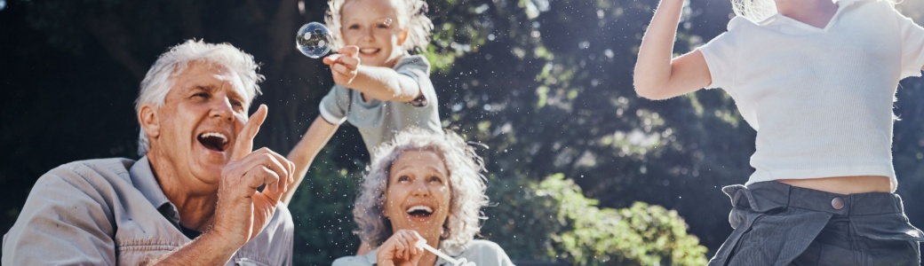 Grandparents blowing bubbles with their grandchildren.