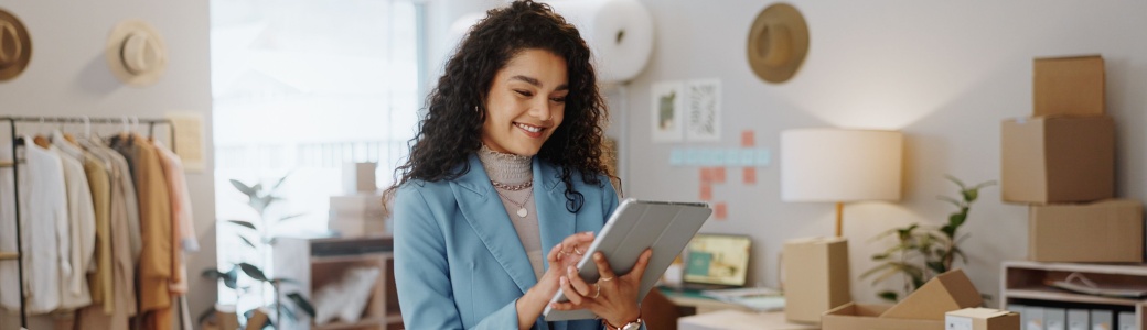 A female business owner using a tablet in an office.