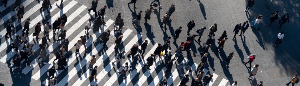 A crowd of people crossing a road.