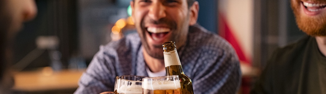 A group of friends clinking beer glasses in a pub.