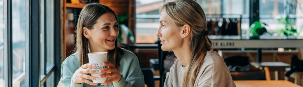 Two women talking in a coffee shop.