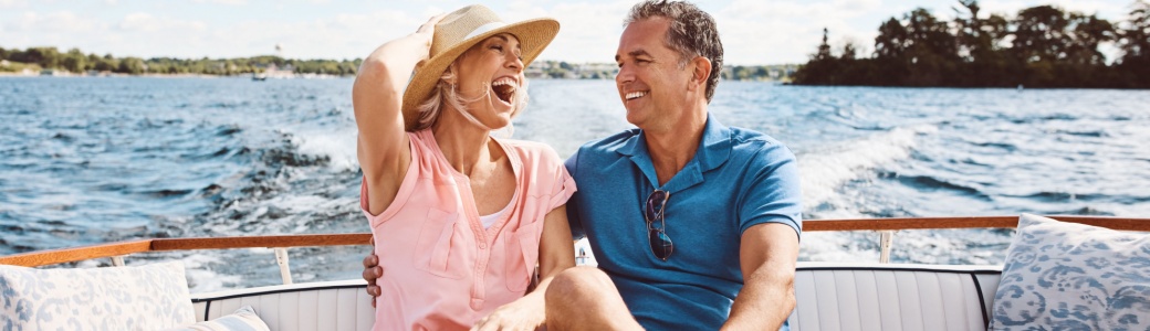 A couple in their 50s laughing on a boat together.