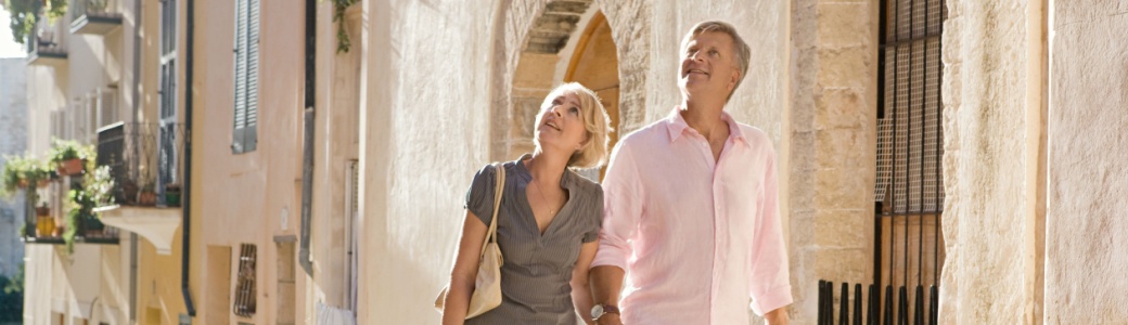 A couple looking at the architecture on an old city street.