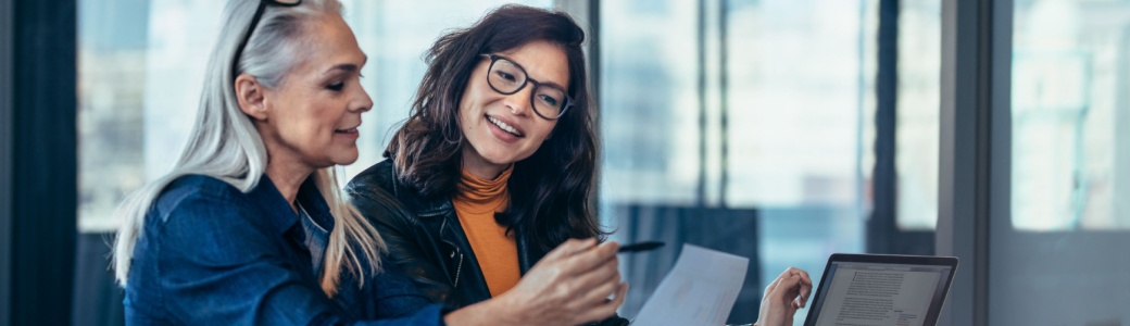 A woman talking to a colleague in an office.